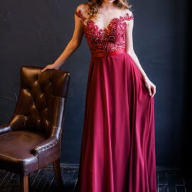 front-view-elegant-girl-red-dress-leans-chair-looks-camera